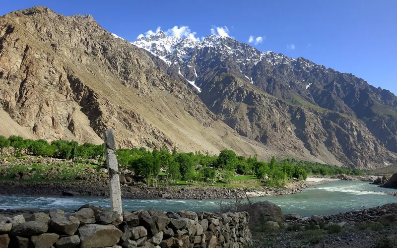 Rock wall and the lush greenery across the river in Afghanistan