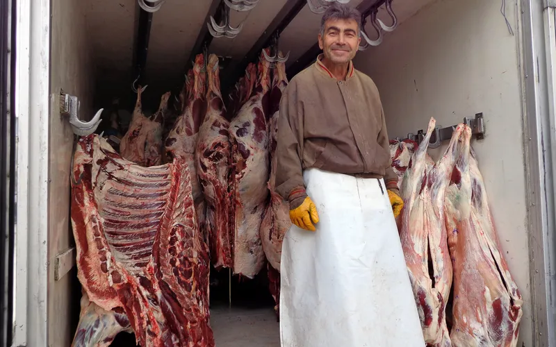 A butcher inspecting meat in the morning